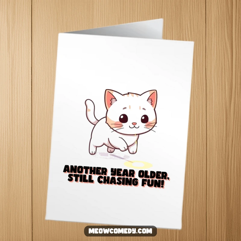 Funny Free Printable Birthday Card: Kawaii cat joyfully chasing a red laser dot across a wooden floor.