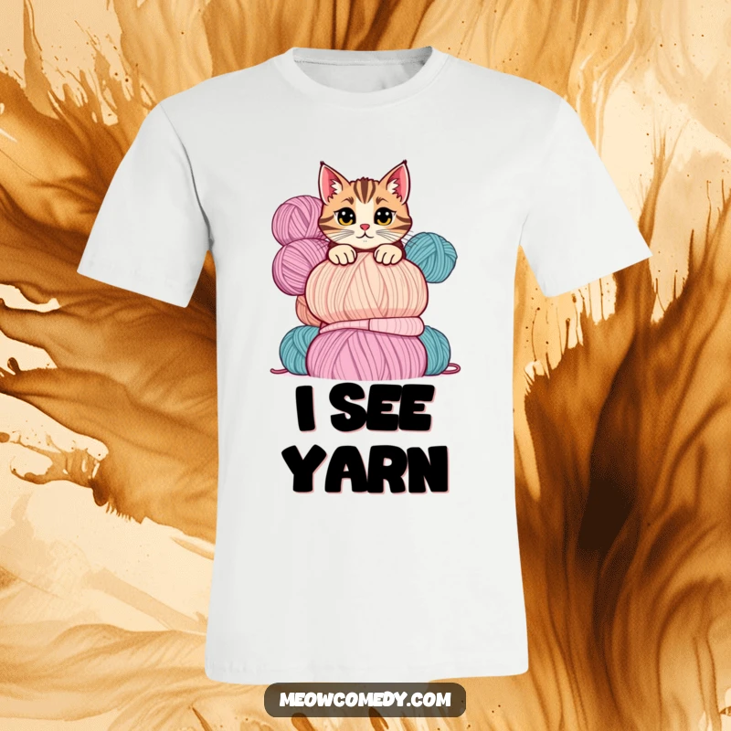 Funny cat t-shirt depicting a mischievous cat peeking slyly over a large, stacked pile of colorful yarn balls.