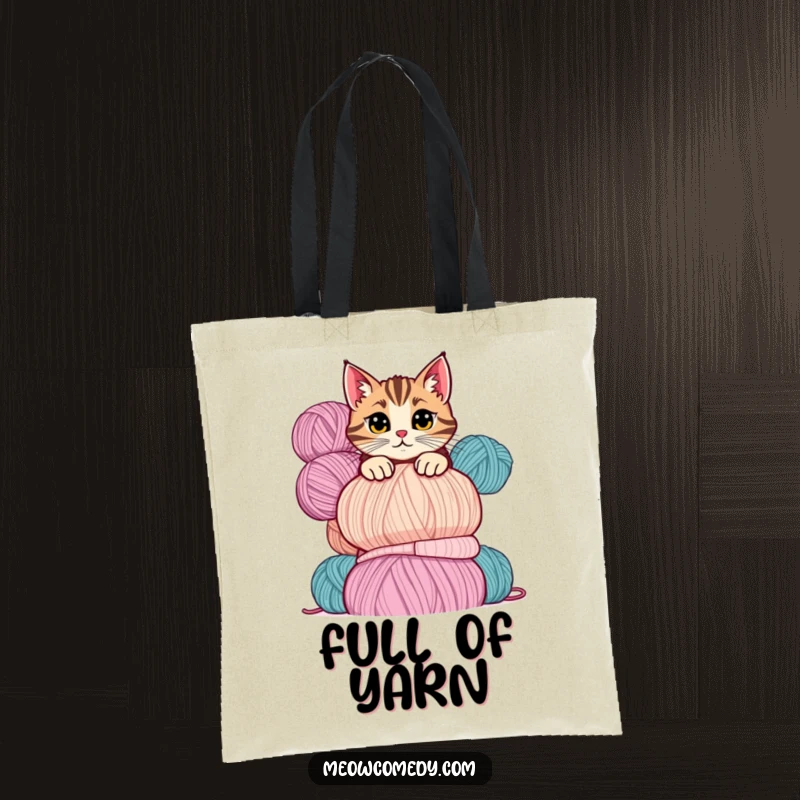 Funny cat tote bag depicting a mischievous cat peeking playfully over a tall stack of colorful yarn balls.